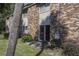 Brick building exterior with sliding glass door leading to a patio, lush landscaping, and palm tree at 809 Andrea Ln, Hanahan, SC 29410