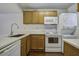 Modern kitchen with white appliances and wood cabinets, and a view of the living room at 809 Andrea Ln, Hanahan, SC 29410