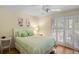 Guest bedroom with a queen bed, light green bedding, and access to a private balcony at 1101 Summerwind Ln, Seabrook Island, SC 29455