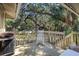 Wooden deck with rocking chair, grill, and view of the wooded area at 1101 Summerwind Ln, Seabrook Island, SC 29455