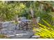 Stone patio with round table and chairs, nestled in a tropical garden setting at 1311 S Jenkins Lagoon Dr, Seabrook Island, SC 29455