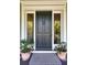 Elegant dark-green front door flanked by sidelights and potted plants at 1311 S Jenkins Lagoon Dr, Seabrook Island, SC 29455
