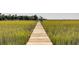 Long wooden walkway extending over marsh grasses toward a distant shoreline at 1311 S Jenkins Lagoon Dr, Seabrook Island, SC 29455