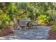 Stone patio with round table and chairs, nestled in a tropical garden setting at 1311 S Jenkins Lagoon Dr, Seabrook Island, SC 29455