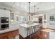 Spacious kitchen boasts white cabinets, large island, stainless steel appliances, and hardwood floors at 738 Hibbens Grant Blvd, Mount Pleasant, SC 29464