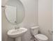 Simple bathroom with pedestal sink, toilet and oval mirror at 1866 Nola Run, Summerville, SC 29485