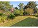 Spacious backyard with lush grass and a variety of trees and plants at 115 Galloway Ct, Moncks Corner, SC 29461