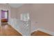Upper hallway with hardwood floors, white railing, and view into bedroom at 413 King St, Mount Pleasant, SC 29464