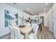 Bright dining room with light wood table, white chairs, and kitchen view at 601 Twin Rivers Dr, Wando, SC 29492