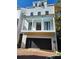 Three-story home with a large black garage door at 24 Iron Frg Aly, Charleston, SC 29403