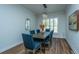 Elegant dining room with hardwood floors, rustic table, and blue upholstered chairs at 145 Hedera Ct, Summerville, SC 29486