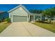 Green house exterior with a two-car garage and a manicured lawn at 145 Hedera Ct, Summerville, SC 29486