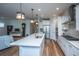 Modern kitchen features white cabinets, stainless steel appliances, and a large island with quartz countertops at 145 Hedera Ct, Summerville, SC 29486