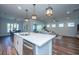 Modern kitchen flows into dining area with hardwood floors and stylish light fixtures at 145 Hedera Ct, Summerville, SC 29486