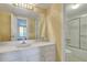 Bathroom with white vanity, shower/tub combo, and yellow striped wallpaper at 330 Concord St # 15E, Charleston, SC 29401