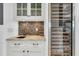 Stylish wet bar with granite countertop, wine fridge, and mosaic tile backsplash at 1913 Mooring Line Way, Mount Pleasant, SC 29466