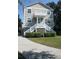 Two story house with light beige siding, white trim, and a front porch at 32 41St Ave, Isle of Palms, SC 29451