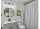 Updated bathroom with pedestal sink, white toilet and striped shower curtain at 107 Hiers Corner Rd, Walterboro, SC 29488