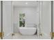 Elegant bathroom featuring a freestanding tub, marble tile, and gold fixtures at 517 Royall Ave, Mount Pleasant, SC 29464