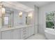Luxurious bathroom with double vanity, gold fixtures, and a freestanding tub at 517 Royall Ave, Mount Pleasant, SC 29464