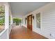 Inviting front porch with wooden flooring, double doors, and white columns at 517 Royall Ave, Mount Pleasant, SC 29464