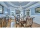 Formal dining room boasts hardwood floors, wainscoting, and a stunning chandelier at 4233 Haulover Dr, Johns Island, SC 29455