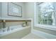 Relaxing bathroom with a garden tub and large window overlooking trees at 4233 Haulover Dr, Johns Island, SC 29455