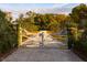 White wooden gate opening to a long private driveway leading to a home at 4285 Clover Hill Rd, Green Pond, SC 29446
