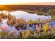 Aerial view of a tranquil lakefront property with colorful autumn foliage at 4285 Clover Hill Rd, Green Pond, SC 29446