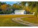 White barn and long private driveway leading to a home with fall foliage at 4285 Clover Hill Rd, Green Pond, SC 29446