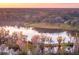 Aerial view showcasing a serene lake setting and a home nestled in nature at 4285 Clover Hill Rd, Green Pond, SC 29446