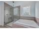 Bathroom with soaking tub, glass shower, and gray tile at 2600 Josiah St, Charleston, SC 29492