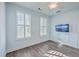 Light blue bedroom with wood flooring, white shutters, and mounted TV at 2600 Josiah St, Charleston, SC 29492