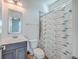 Small bathroom with white toilet and shower, gray vanity, and patterned curtain at 2600 Josiah St, Charleston, SC 29492