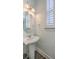 Small bathroom with pedestal sink, white shutters, and dark hardwood floor at 2600 Josiah St, Charleston, SC 29492