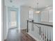 Upstairs hallway with hardwood floors, white railings, and a door to outside at 2600 Josiah St, Charleston, SC 29492