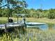 Private boat dock with a green and white motorboat on a calm waterway at 1894 Capri Dr, Charleston, SC 29407