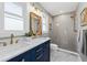 Updated bathroom with navy vanity, quartz countertops, and walk-in shower at 1894 Capri Dr, Charleston, SC 29407