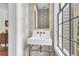 Stylish powder room features a pedestal sink, brass fixtures, and patterned wallpaper at 64 Warren St, Charleston, SC 29403