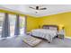 Spacious bedroom with yellow walls, gray carpet, and access to the backyard at 428 Carn St, Walterboro, SC 29488