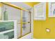 Bathroom with a shower/tub combo, white shelving and yellow walls at 428 Carn St, Walterboro, SC 29488