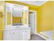 Bathroom with a white vanity, a mirrored medicine cabinet, and yellow walls at 428 Carn St, Walterboro, SC 29488
