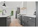 Modern kitchen with dark cabinets, marble countertops and herringbone floor at 3 Penn Ave, Charleston, SC 29407
