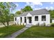 Charming white cottage with gray roof, landscaping, and walkway at 3 Penn Ave, Charleston, SC 29407
