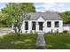 Charming white farmhouse with gray roof, landscaping, and walkway at 3 Penn Ave, Charleston, SC 29407