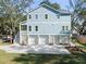 Three-car garage and elevated home with light blue siding and white trim at 1208 Stone Post Rd, Charleston, SC 29412