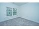Bright bedroom with gray carpeting and two windows at 1103 Twin Rivers Drive # 71, Wando, SC 29492