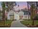 Farmhouse exterior at dusk showcasing landscaping and driveway at 3904 Delinger Dr, Mount Pleasant, SC 29466