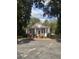 Quaint white cottage with red trim and a spacious front yard at 507 E 5Th N St, Summerville, SC 29483