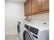 Laundry room with white washer and dryer and wood cabinets at 180 Cantona Dr, Summerville, SC 29483